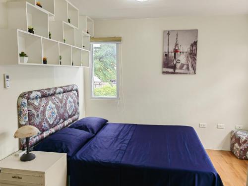 达沃市Casa Felicitas 1的一间卧室设有蓝色的床和窗户。