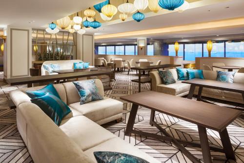 浦安东京湾喜来登大酒店 的一个带沙发和桌子的酒店大堂以及一间餐厅