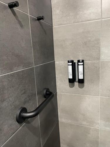 霍巴特郝伯特贝斯特韦斯特酒店的墙上的淋浴间配有2瓶洗发水