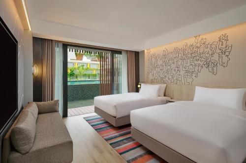 库塔Aloft Bali Kuta at Beachwalk的酒店客房,设有两张床和一张沙发