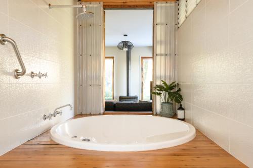 戴尔斯福特Azidene House & Spa Apartment的带窗户的浴室内的白色大浴缸