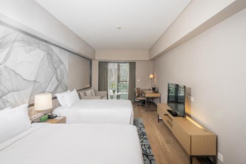 上海长河国际公寓新天地的酒店客房设有两张床和一台平面电视。