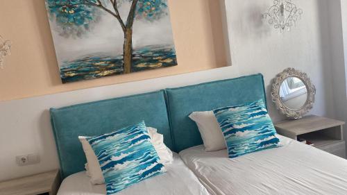 斯卡拉伯塔麦斯INROY SEA VIEW APARTMENTS的一间卧室配有蓝色沙发和两个枕头