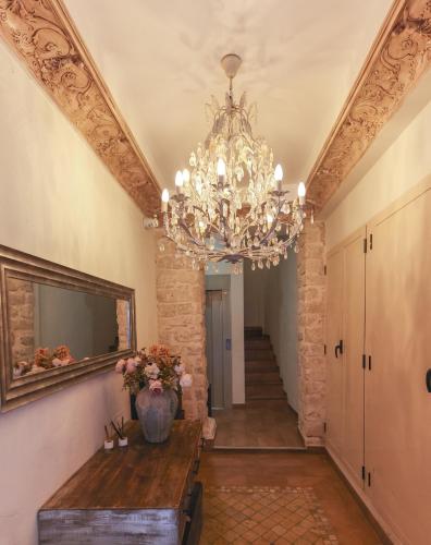 阿利坎特Dorinda Rooms的走廊上设有吊灯、桌子和楼梯