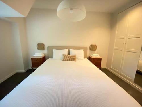 吕伐登Parkzicht的一间卧室配有一张带2个床头柜的大型白色床