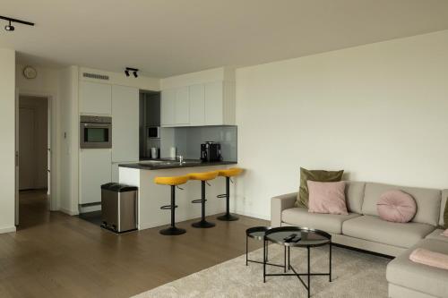 安特卫普UNIEK appartement - mooiste en hoogste uitzicht op Antwerpen! - incl gratis parking的带沙发的客厅和厨房