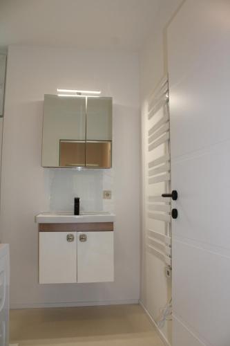 格蒙登Wohnung am Traunsee的白色的厨房配有水槽和橱柜