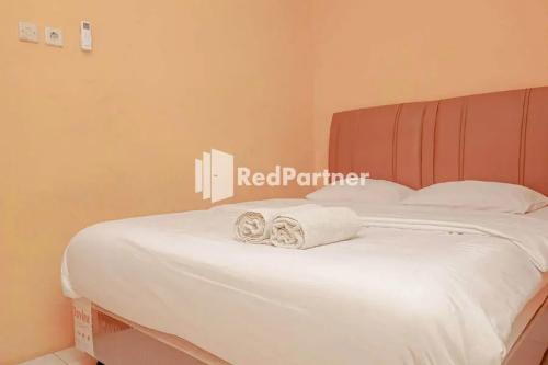 井里汶Pondok Damai Guest House Syariah Mitra RedDoorz的一张白色的床,上面有两张折叠毛巾