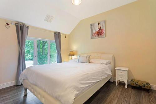 ThamesmeadSnug & Cosy Home In Thamesmead Overlooking A Park的卧室设有一张白色大床和一扇窗户。