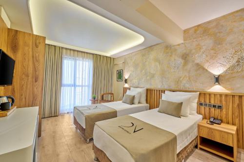 安塔利亚Der Inn Hotel Lara的酒店客房设有两张床和电视。