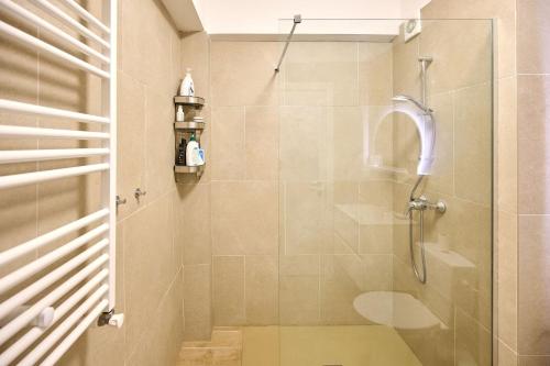 马马亚Infinity Breezes Apartment Beach Resort - parking的带淋浴的浴室和玻璃门