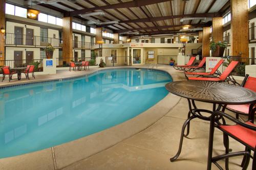 WoodwardNorthwest Inn的酒店的大型游泳池配有桌椅