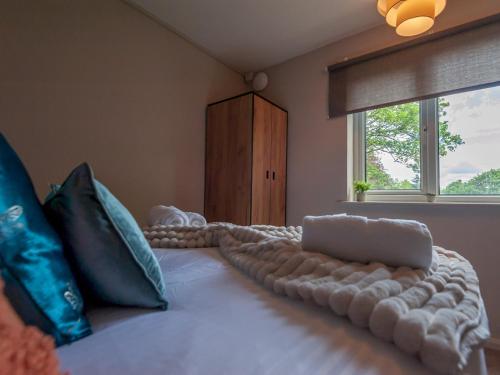 利兹Pass the Keys Couples Haven on the Banks of the River Aire的卧室配有带枕头的大床和窗户。
