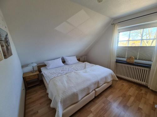 格洛米茨Bootshaus, App 3的卧室配有白色的床和窗户。