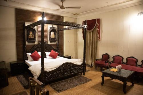 安巴拉Ambala Haveli的一间卧室配有一张带红色枕头的天蓬床
