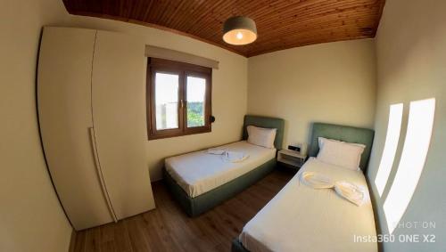 萨莫色雷斯Villa Potamia的小房间设有两张床和一台冰箱