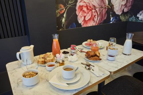 巴黎Hôtel Beauquartier Montmartre的一张桌子,上面有早餐食品和咖啡