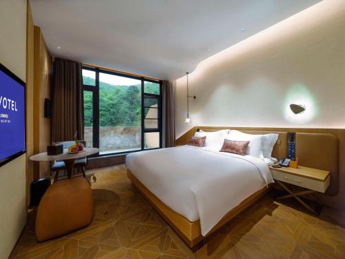 乡宁云丘山诺富特酒店的一间卧室设有一张大床和一个大窗户