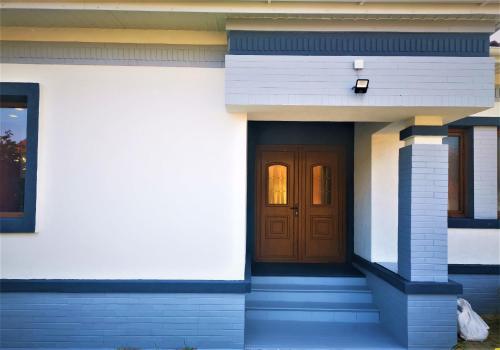 Remetea MareNETFLIX & CHILL的一间设有棕色门和楼梯的房子