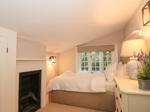 新米尔顿The Old Cottage的一间卧室配有一张床和一个壁炉