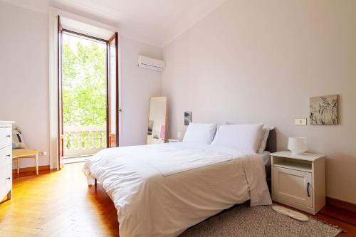米兰Liberty Home的白色的卧室设有一张大床和一个窗户