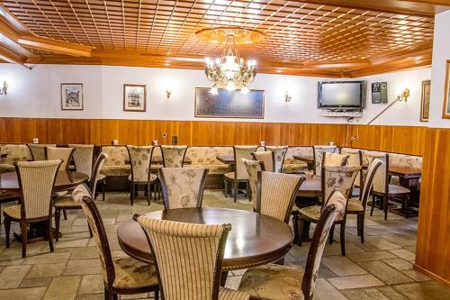 美特索文阿波罗酒店的一间带桌椅和电视的用餐室