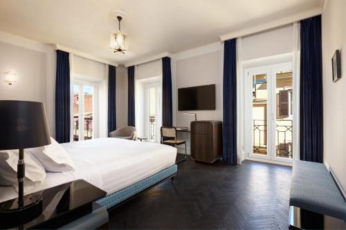 罗马TB Place Roma的一间卧室配有一张床和一张书桌及电视