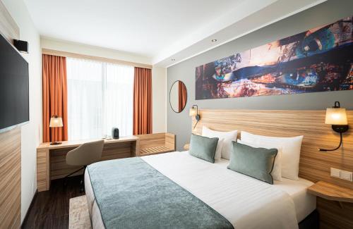 林茨Leonardo Boutique Hotel Linz City Center的一间设有大床和窗户的酒店客房