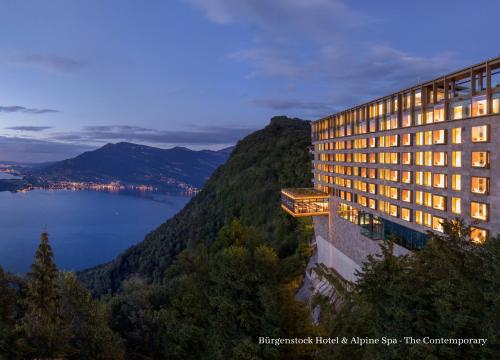 比尔根山Bürgenstock Hotel & Alpine Spa的一座享有水景的山间建筑