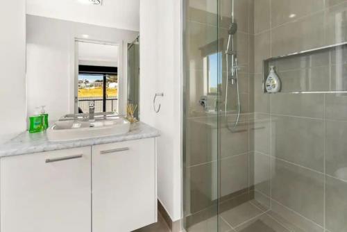 圣雷莫Castaway Views on Broadway的一间带玻璃淋浴和水槽的浴室