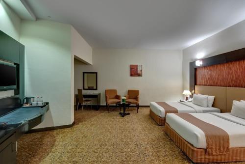 沙迦阿雅那酒店的酒店客房配有两张床和一张书桌