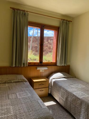 努奇堡Hostal Alt Llobregat的一间卧室设有两张床和窗户。