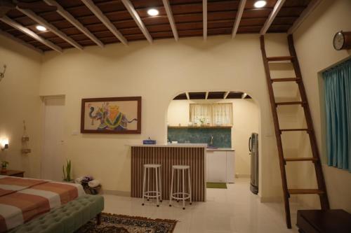 瓦尔卡拉Cascara Beach Resort的一间设有床铺的客房和一间带梯子的厨房