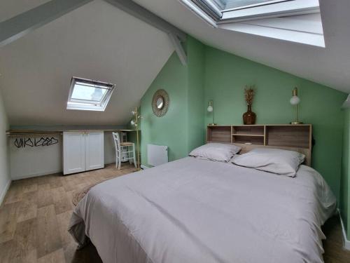 索米尔Superbe duplex La Verrière chic, cosy et spacieux的一间卧室设有一张带绿色墙壁的大床