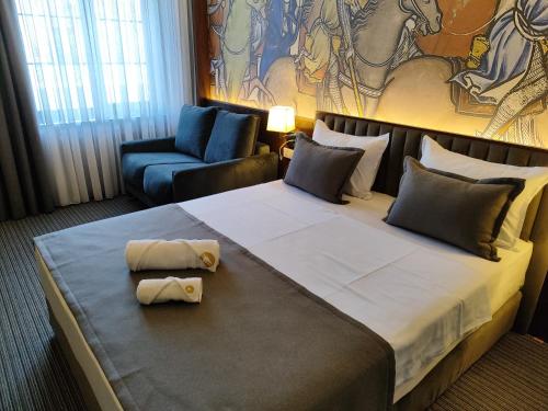 久姆里Orienta Hotel Gyumri的酒店客房带一张大床和一把椅子