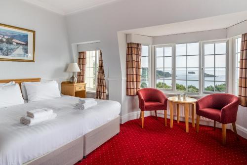 托基The Headland Hotel & Spa的酒店客房带一张床、一张桌子和椅子