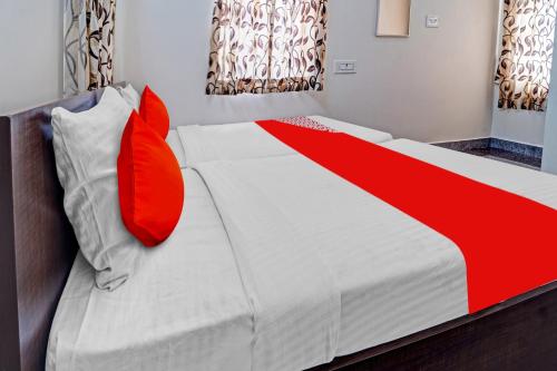 NāmakkalSuper OYO Flagship Royal Residency的一间卧室配有红色枕头的床