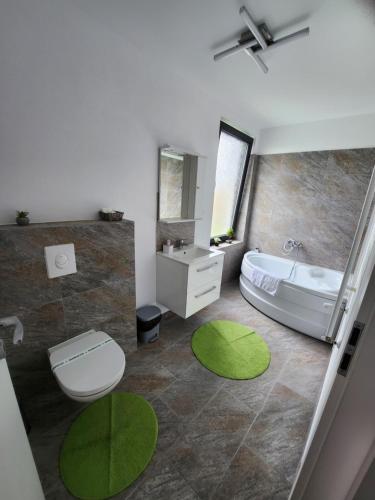 DumbrăviţaArmins's Residence 2 - Villa的浴室设有白色浴缸和绿色地毯。