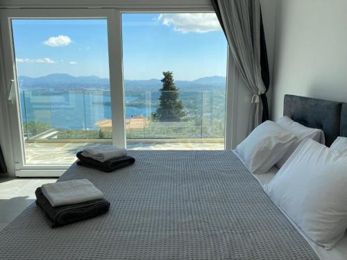 SpartýlasRIZARIA sea view house的一张带两张毛巾的床和大窗户