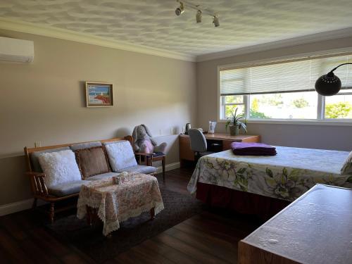 夏洛特顿Xinglin house的一间卧室配有一张床、一把椅子和一张书桌