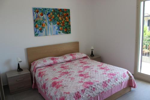 加里Casa vacanze - Orto dei Limoni的卧室配有一张床,墙上挂有绘画作品