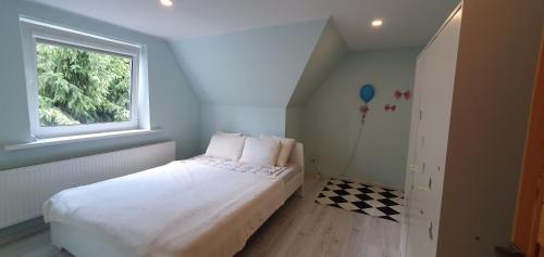 考纳斯ŠILAINIŲ APARTAMENTAI的一间小卧室,配有白色的床和窗户