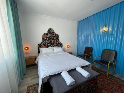 卡拉科尔Duet Hostel & Hotel的一间卧室配有一张大床和两把椅子