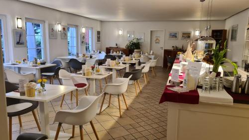 洛布Das kleine Hotel auf Mönchgut的一间设有白色桌子和白色椅子的餐厅