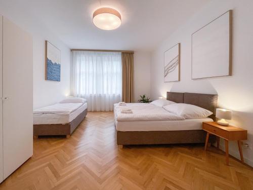 布拉迪斯拉发Elysian Apartment的铺有木地板的客房内的两张床