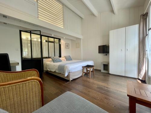 雷岛林滩La Villa - Hôtel Bien Être的一间卧室配有一张床和一台电视。
