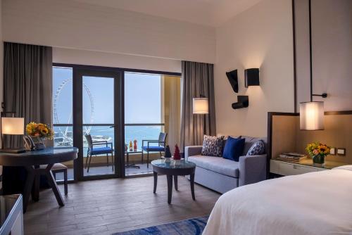迪拜安瓦吉罗塔纳朱梅拉海滩酒店-迪拜的酒店客房配有床、沙发和桌子。