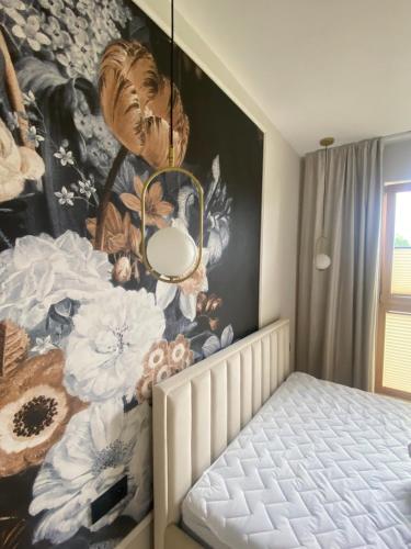 格但斯克Apartament PORTO的卧室的墙上挂着花卉壁画