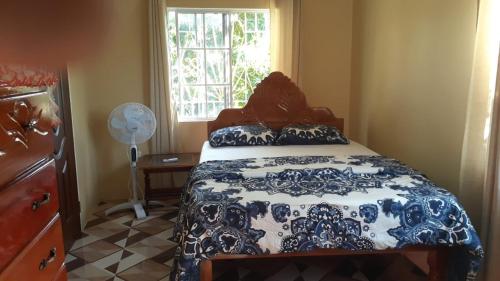 特雷热比奇Mango tree Oasis的卧室配有蓝色和白色的床和窗户。