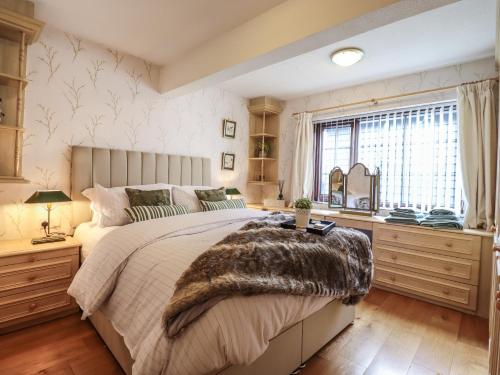 科尔切斯特256 London Road的一间卧室设有一张大床和一个窗户。